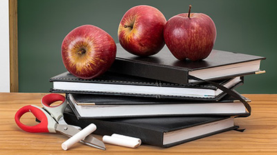 Stock photo of books, apples, scissors and chalk